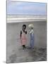 Boy and Girl on Beach Listening to Sea Shell-Nora Hernandez-Mounted Giclee Print