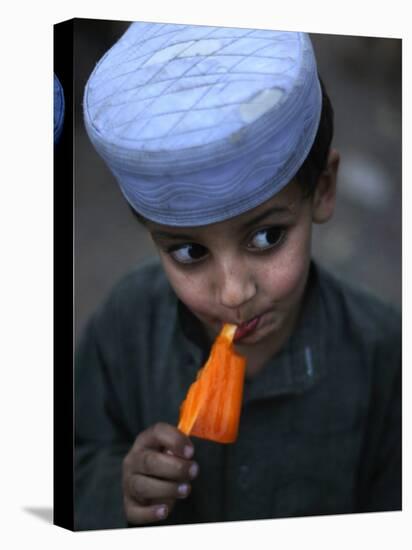 Boy Eats an Ice Lolly in a Neighborhood on the Outskirts of Islamabad, Pakistan-null-Stretched Canvas