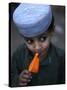 Boy Eats an Ice Lolly in a Neighborhood on the Outskirts of Islamabad, Pakistan-null-Stretched Canvas