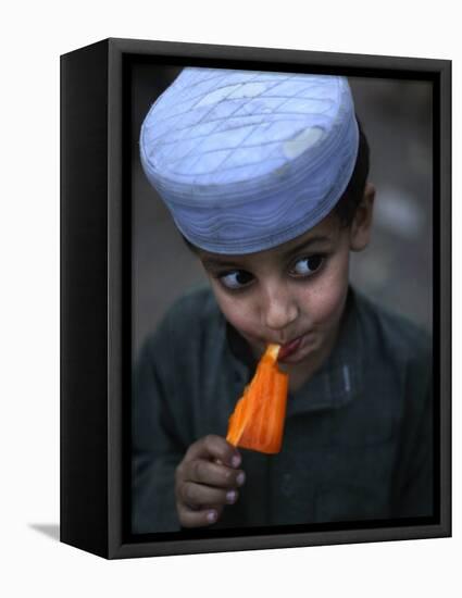 Boy Eats an Ice Lolly in a Neighborhood on the Outskirts of Islamabad, Pakistan-null-Framed Stretched Canvas