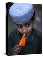 Boy Eats an Ice Lolly in a Neighborhood on the Outskirts of Islamabad, Pakistan-null-Stretched Canvas