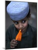 Boy Eats an Ice Lolly in a Neighborhood on the Outskirts of Islamabad, Pakistan-null-Mounted Photographic Print