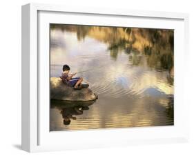Boy Fishing from a Rock on a Pond-null-Framed Photographic Print