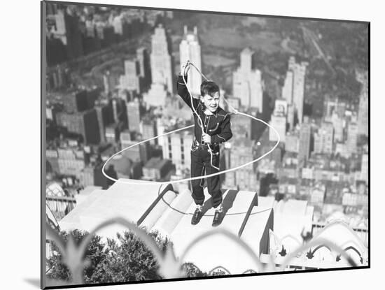 Boy on Ledge Twirling a Lasso-null-Mounted Photographic Print