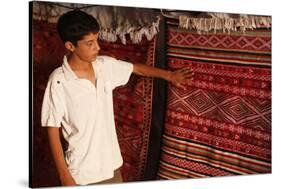 Boy showing a rug in a carpet shop, Toujane, Tunisia-Godong-Stretched Canvas