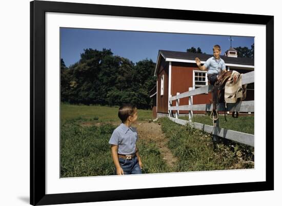 Boy Sitting on Fence Waving to Friend-William P. Gottlieb-Framed Photographic Print