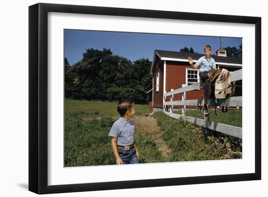 Boy Sitting on Fence Waving to Friend-William P. Gottlieb-Framed Photographic Print