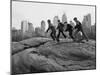 Boys Climbing About on Rock Formation in Central Park as Essex House Looms Amidst Skyline of City-Bill Ray-Mounted Photographic Print