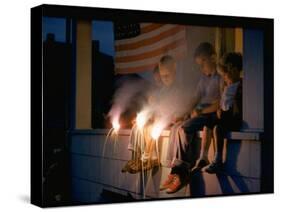 Boys Sitting on Porch Holding Sparklers, with US Flag in Back, During Independence Day Celebration-Nat Farbman-Stretched Canvas