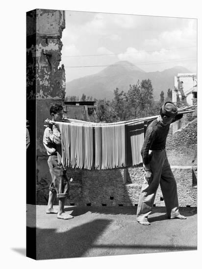 Boys Working in Pasta Factory Carry Rods of Pasta to Drying Rooms-Alfred Eisenstaedt-Stretched Canvas