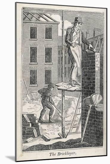 Bricklayer Standing on a Rather Precarious Looking Scaffold, His Assistant Mixes Mortar Behind Him-null-Mounted Photographic Print