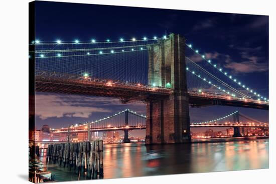 Brooklyn Bridge Closeup over East River at Night in New York City Manhattan with Lights and Reflect-Songquan Deng-Stretched Canvas