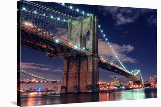 Brooklyn Bridge Closeup over East River at Night in New York City Manhattan with Lights and Reflect-Songquan Deng-Stretched Canvas