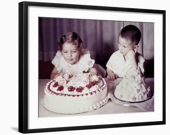 Brother Watches His Sister Blow Out Candles on Birthday Cake, Ca. 1956-null-Framed Photographic Print