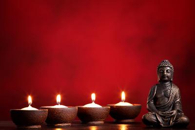 &lsquo;Buddha and Candles on Red Background, Religious Concept.&rsquo; Photographic