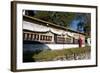 Buddhist Monk in Red Robes Turning Prayer Wheels in Contemplative Morning Prayer-Annie Owen-Framed Photographic Print