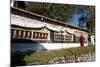 Buddhist Monk in Red Robes Turning Prayer Wheels in Contemplative Morning Prayer-Annie Owen-Mounted Photographic Print