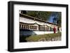 Buddhist Monk in Red Robes Turning Prayer Wheels in Contemplative Morning Prayer-Annie Owen-Framed Photographic Print