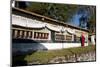 Buddhist Monk in Red Robes Turning Prayer Wheels in Contemplative Morning Prayer-Annie Owen-Mounted Photographic Print