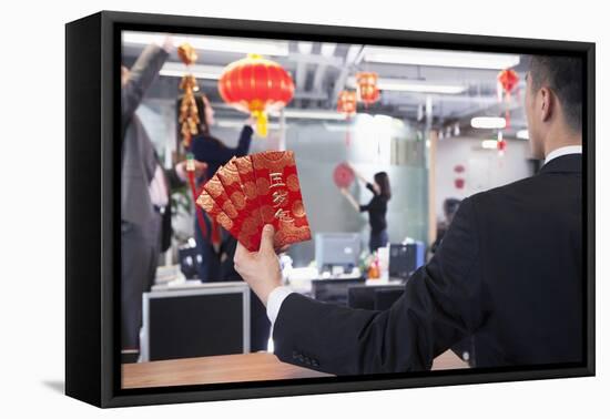 Businessman Holding Red Envelopes and Coworkers Hanging Decorations for Chinese New Year-XiXinXing-Framed Stretched Canvas