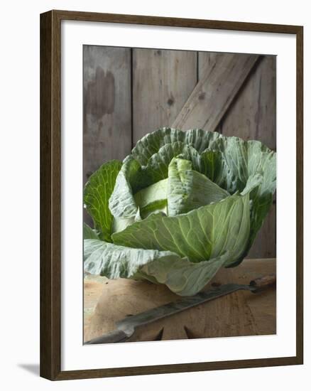 Cabbage on Chopping Board in Front of Wooden Wall-null-Framed Photographic Print