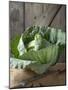 Cabbage on Chopping Board in Front of Wooden Wall-null-Mounted Photographic Print