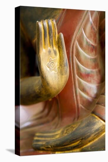 Cambodia, Siem Reap, golden hands on red wood statue of Buddha.-Merrill Images-Stretched Canvas