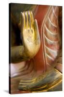 Cambodia, Siem Reap, golden hands on red wood statue of Buddha.-Merrill Images-Stretched Canvas