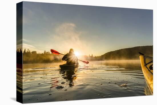 Canada, British Columbia. A kayaker paddles in morning mist on a Canadian lake.-Gary Luhm-Stretched Canvas