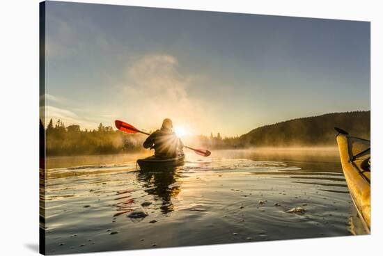 Canada, British Columbia. A kayaker paddles in morning mist on a Canadian lake.-Gary Luhm-Stretched Canvas