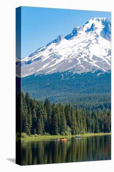 Canoes and rowboat on the still waters of Trillium Lake with Mount Hood, part of the Cascade Range,-Martin Child-Stretched Canvas