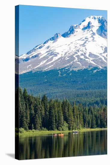 Canoes and rowboat on the still waters of Trillium Lake with Mount Hood, part of the Cascade Range,-Martin Child-Stretched Canvas