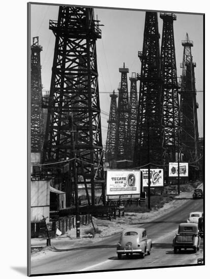 Car Traffic on Highway Next to Advertising Billboards and Oil Well Towers, Signal Hill Oil Field-Andreas Feininger-Mounted Photographic Print