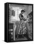 Career Girl Hostedd Joan Wilson in skirt and sleeveless blouse cooking in kitchen-Nina Leen-Framed Stretched Canvas