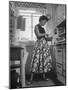 Career Girl Hostedd Joan Wilson in skirt and sleeveless blouse cooking in kitchen-Nina Leen-Mounted Photographic Print