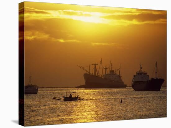 Cargo Ships and Outrigger Canoe in Manila Bay at Sunset, in the Philippines, Southeast Asia-Robert Francis-Stretched Canvas