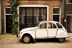 A Scooter Parked on the Sidewalk Outside of Oude Kerk Church in Amsterdam, Netherlands-Carlo Acenas-Photographic Print