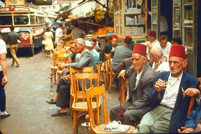 Lebanese Gentlemen sits at a steetside cafe sipping tea and smoking traditional narghile pipes