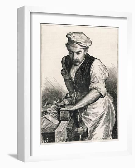 Carpenter Planes a Piece of Wood Creating Lots of Wood Shavings-null-Framed Art Print