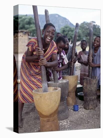 Cheerful Young Girls Pound Corn Outside Families' Homes Near Monkey Bay, South End of Lake Malawi-Nigel Pavitt-Stretched Canvas