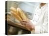 Chef Hurrying Through Kitchen with Baguettes-null-Stretched Canvas