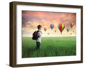 Child Carrying A Backpack Standing On A Green Meadow With Hot-Air Balloons In The Background-olly2-Framed Art Print