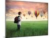 Child Carrying A Backpack Standing On A Green Meadow With Hot-Air Balloons In The Background-olly2-Mounted Art Print
