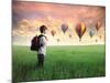 Child Carrying A Backpack Standing On A Green Meadow With Hot-Air Balloons In The Background-olly2-Mounted Art Print