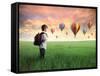 Child Carrying A Backpack Standing On A Green Meadow With Hot-Air Balloons In The Background-olly2-Framed Stretched Canvas