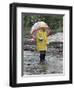 Child in Rain Gear with Umbrella Playing in Puddle.-Nora Hernandez-Framed Giclee Print