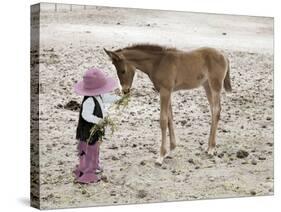 Child in Western Wear Feeding a Pony-Nora Hernandez-Stretched Canvas