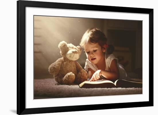 Child Little Girl Reading a Magic Book in the Dark Home with a Toy Teddy Bear-evgeny atamanenko-Framed Photographic Print