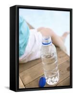 Child Sitting Beside Bottle of Water on Edge of Pool-null-Framed Stretched Canvas