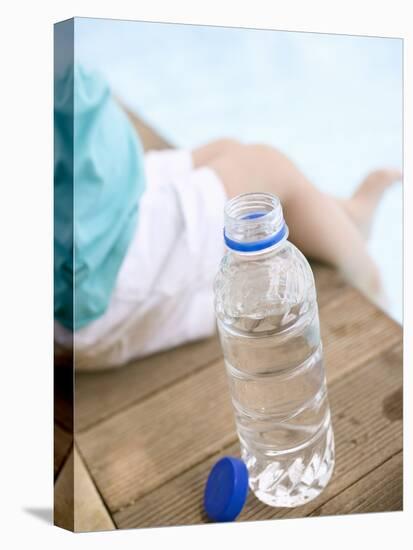 Child Sitting Beside Bottle of Water on Edge of Pool-null-Stretched Canvas